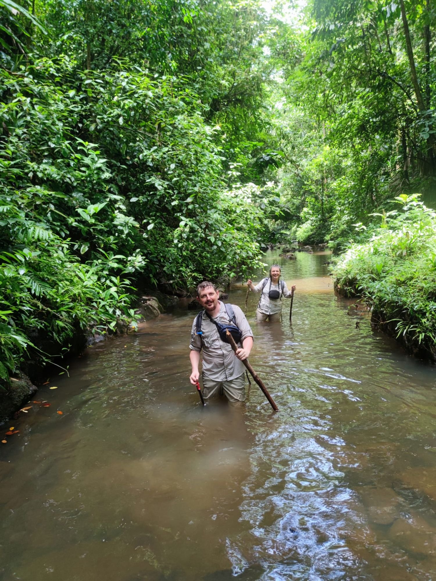 Camelia and Dacian Brandas wading through a river in Solarpunk Forest.