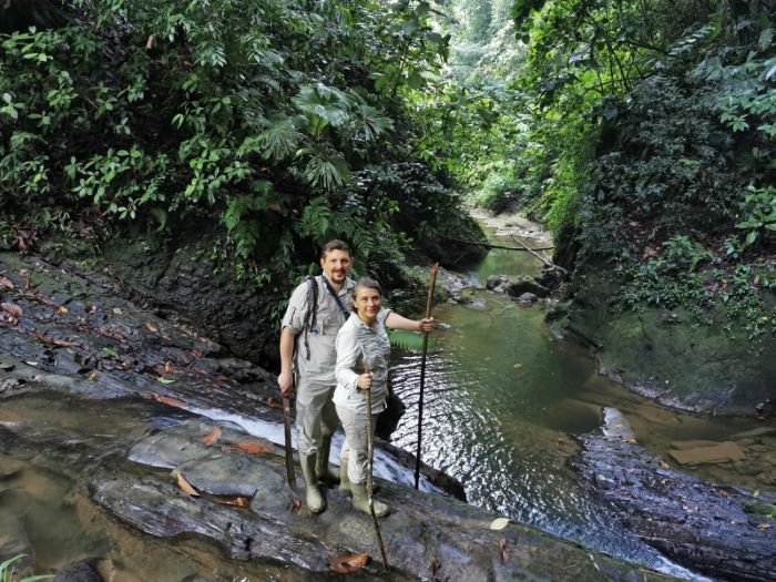 Camelia and Dacian Brandas standing on rocks beside a forest stream.