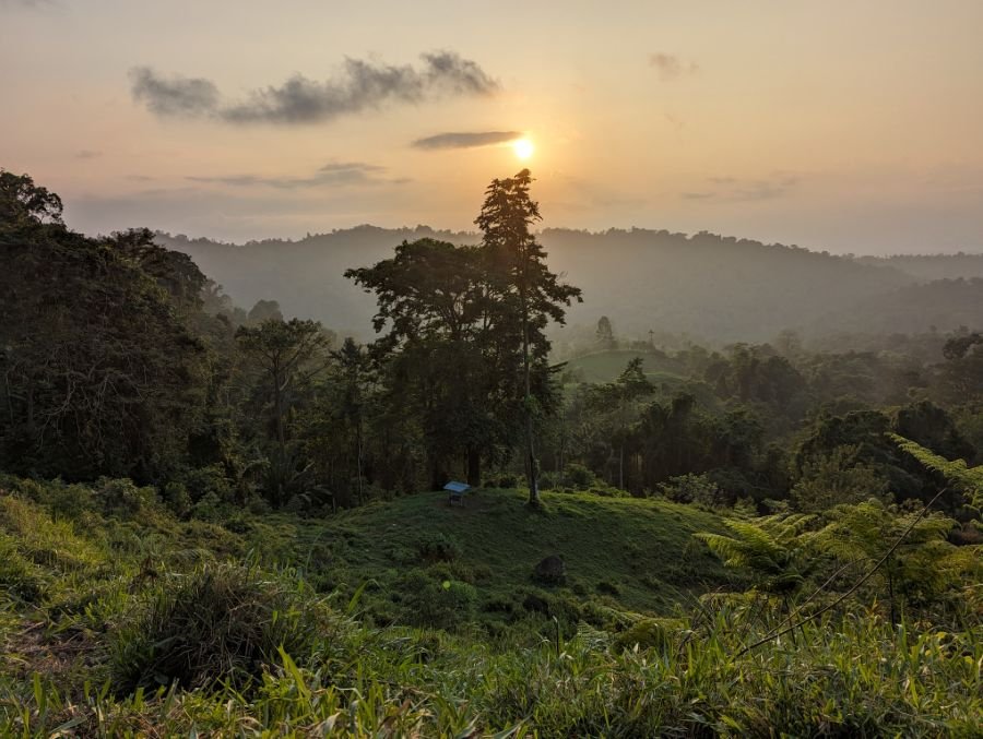 The sun setting over forested hills in the Talamanca region.